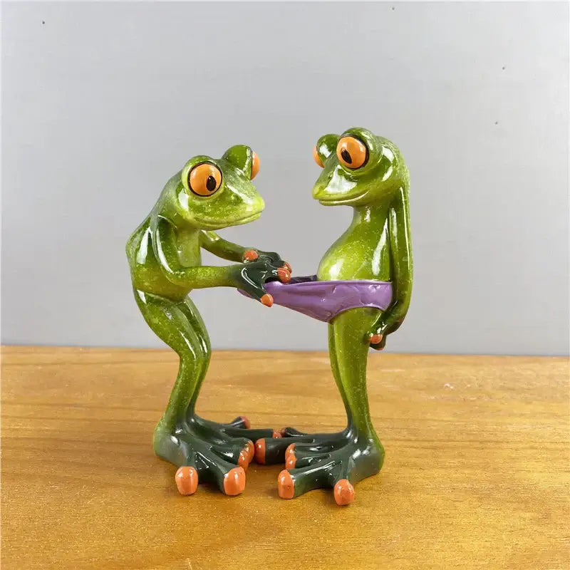 Modern green and orange leggy frog couple figurine holding purple bikini bottom decorbites leggy frog decor