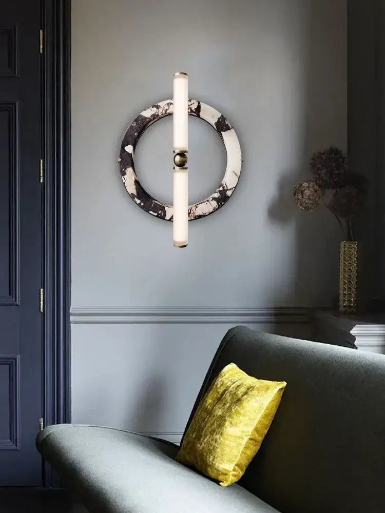 Modern wall lamp with green black marble circular base, frosted glass tubes, and gold-toned accent for bedroom use