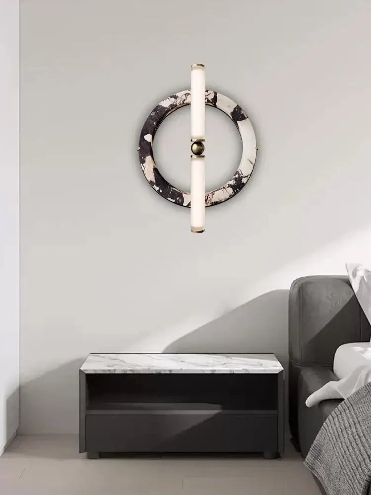 Modern wall lamp with a circular green black marble base and frosted glass tubes for bedroom lighting