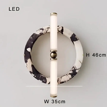 Modern wall lamp with a white marble circular base and sleek cylindrical fixture for bedroom green black marble decor