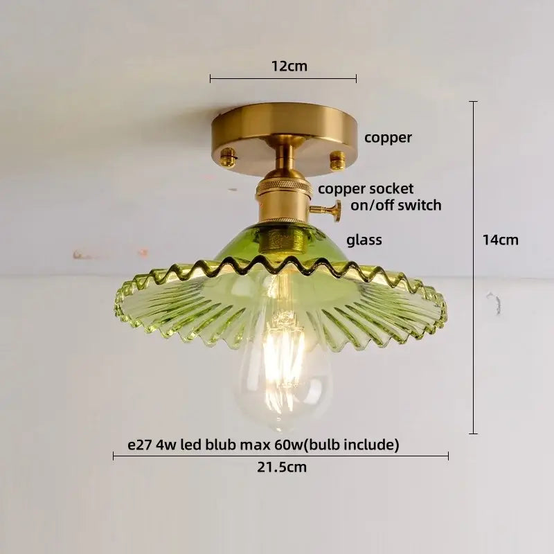 A modern green glass leaf flush mounted ceiling light with a brass copper base and scalloped glass shade for bedroom