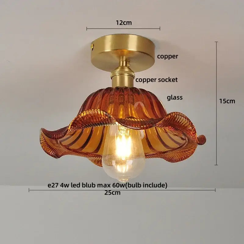 A warm amber glass flush mounted ceiling light with copper base and wavy design for modern bedroom use