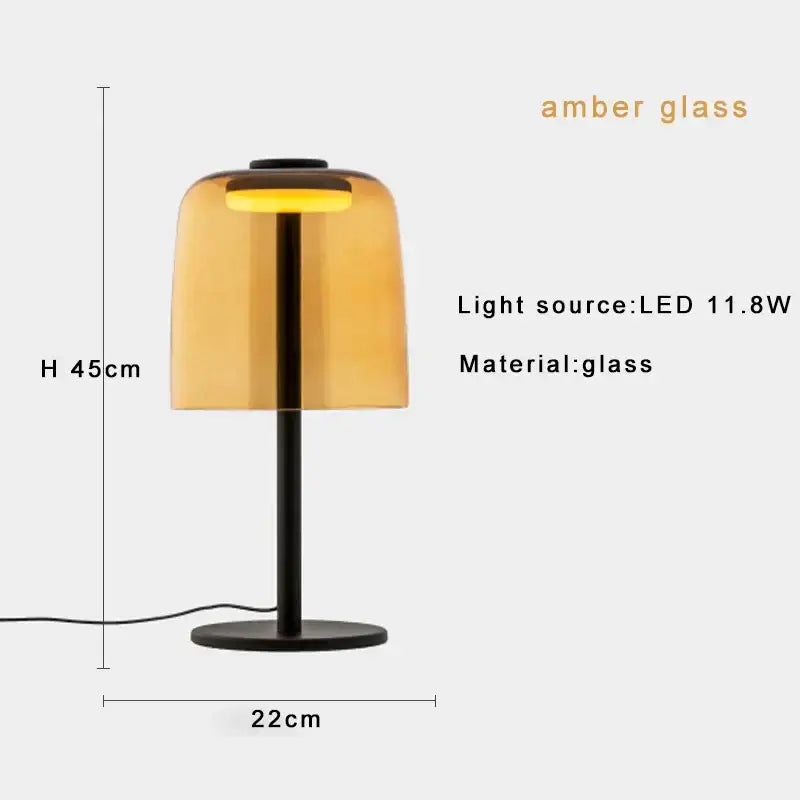 Amber glass table lamp with sleek black metal base and stem complementing modern green glass table lamp for bedroom
