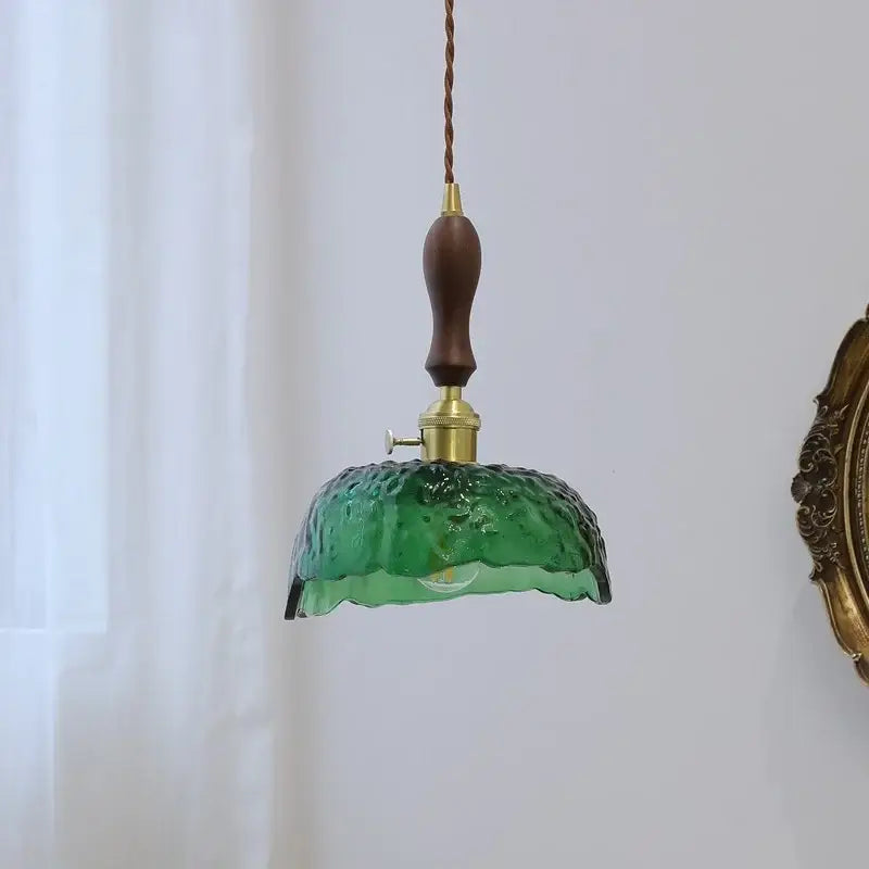 Modern green glass walnut pendant light featuring textured emerald glass, walnut wood handle, and brass hardware for dining room