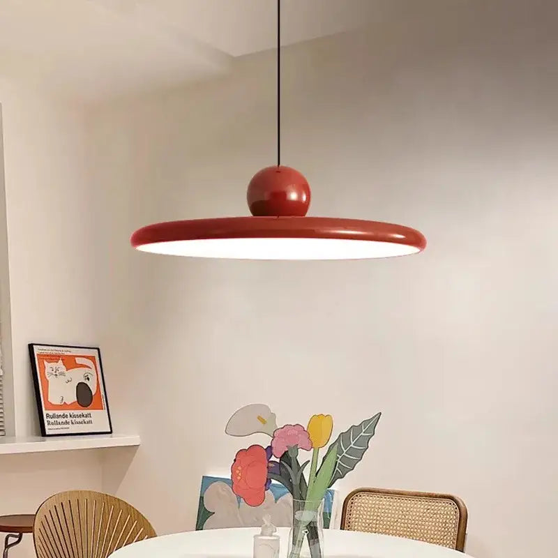 A sleek modern red pendant light with a circular disc and spherical top for decorbites cream wind saucer decor