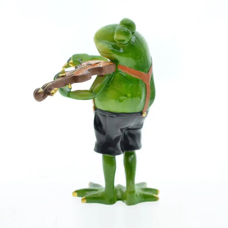 Modern green resin frog band figurine wearing black shorts and orange suspenders playing a brown violin decorbites frog band