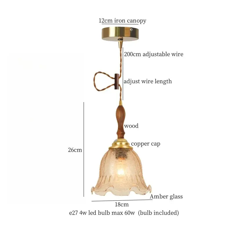 Modern green wave glass pendant light with warm amber glass, wooden stem, brass accents, and adjustable wire suspension