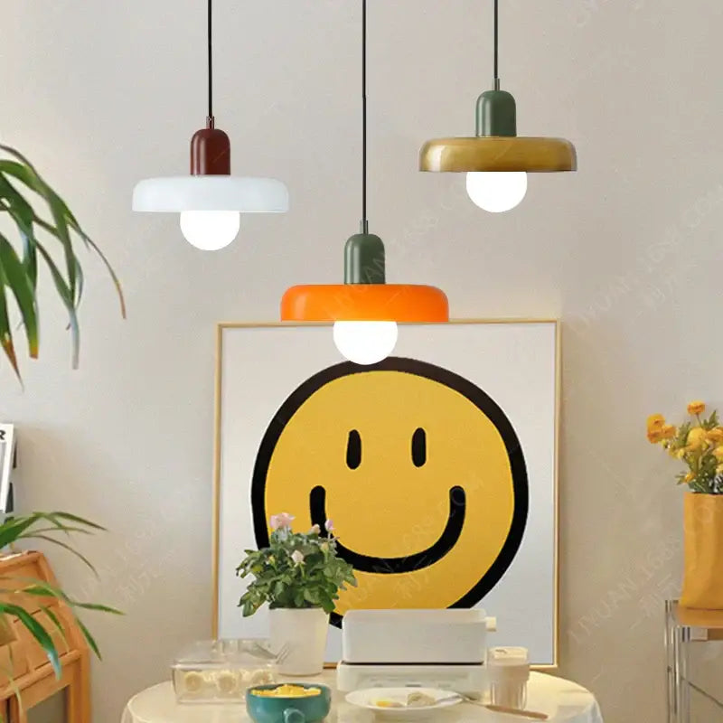 Modern green and white colorful glass pendant lights with matte rounded shades hang above a dining table decorbites colorful glass pendant