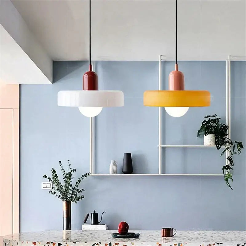 Two modern pendant lights with matte red and orange shades complement decorbites colorful glass pendant dining room decor