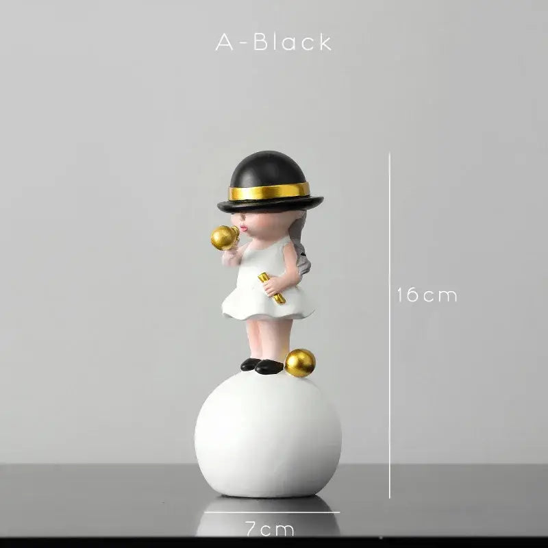 A miniature figurine of a girl in a white dress and black hat holding golden objects for bubble gum blowing decor