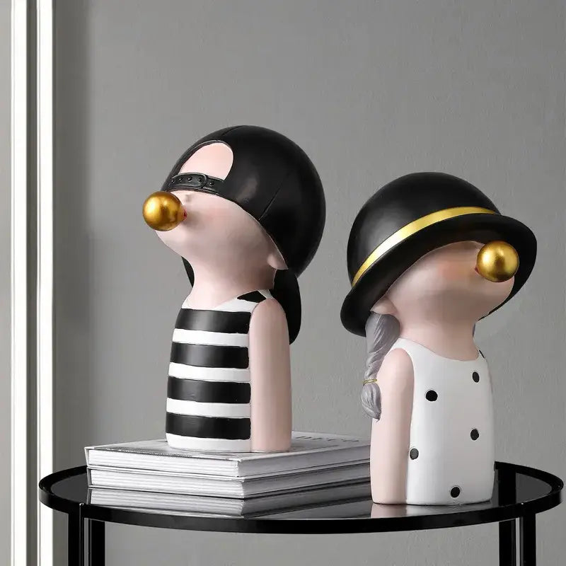 Modern green and white polka dot bubble gum blowing statue featuring two glossy black figurines with gold bubble gum