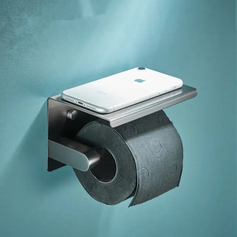 Modern grey bathroom accessories set featuring a brushed stainless steel toilet paper holder with integrated shelf holding iphone