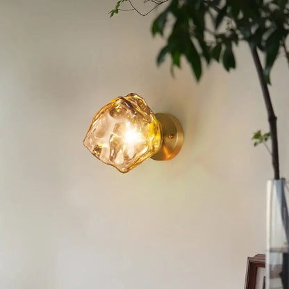 Golden brass wall lamp with translucent amber faceted crystal shade in modern decorbites grey glass led sconce style
