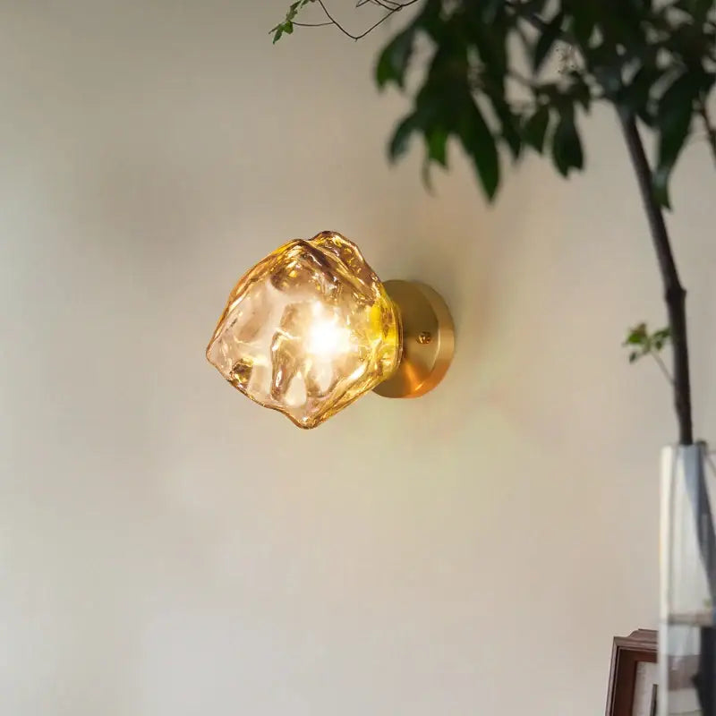 Golden brass wall lamp with translucent amber faceted crystal shade in modern decorbites grey glass led sconce style