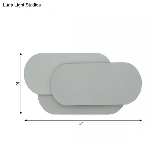 Modern grey oval metal sconce with overlapping panels for bedroom led wall light illumination