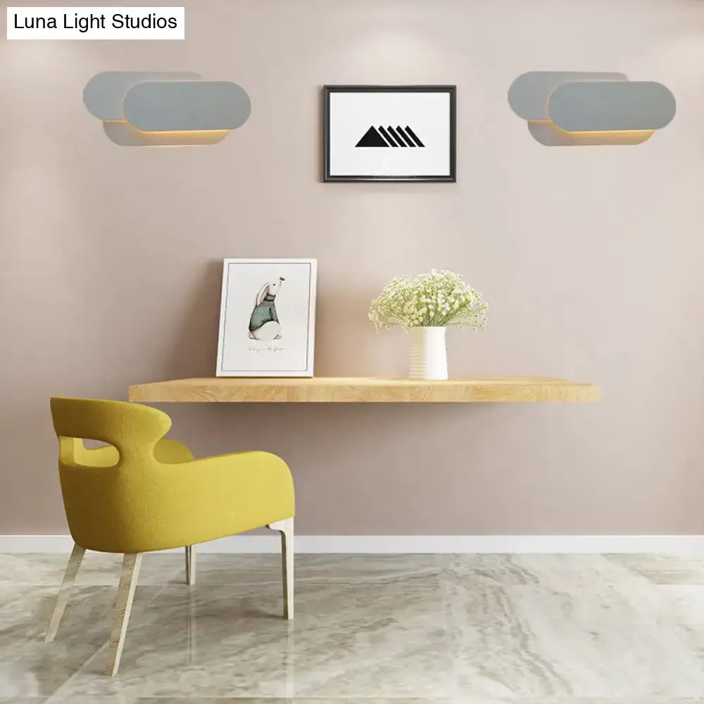 Modern grey oval metal sconce with warm LED lighting shaped like a cloud for bedroom wall lighting