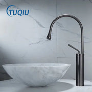 Modern gun grey brass basin faucet with sleek curved spout and cylindrical base beside white marble sink decorbites gun grey