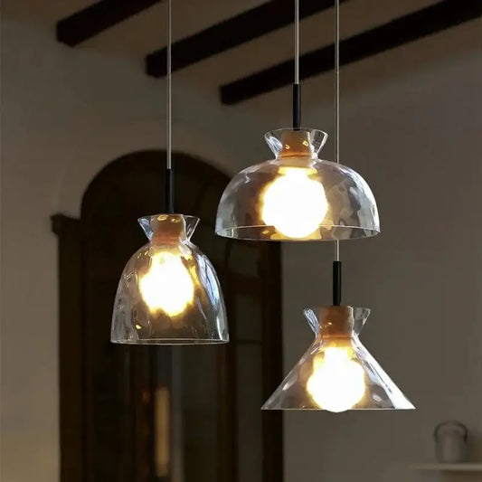 Three modern decorbites clear glass pendant lamps with hammered shades and black metal fixtures for kitchen lighting