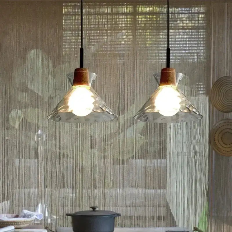 Two modern hammered clear glass pendant lamps with textured shades and warm wooden accents for kitchen decorbites clear glass
