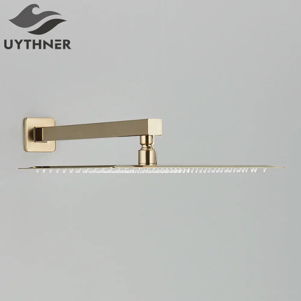 Gold-finished modern hammered rectangular wall mounted shower head with sleek design and multiple nozzles along edge