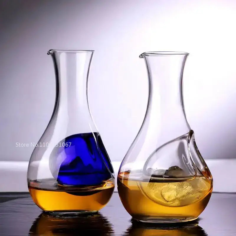 Two clear decorbites crystal glass wine decanters with blue and amber liquids and ice cubes for modern dining room decor