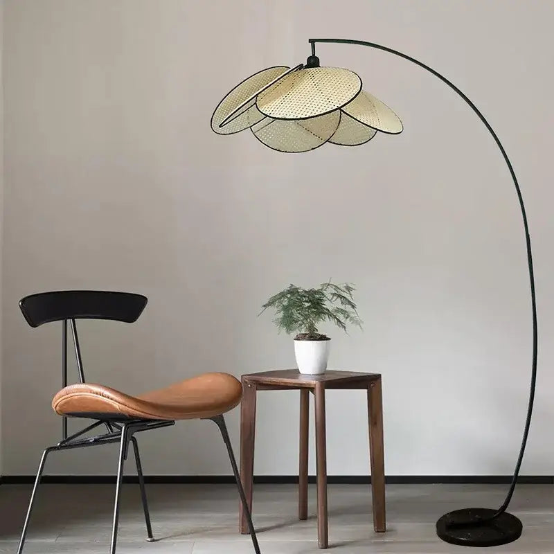 Modern hand made rattan pendant light with a curved black metal floor lamp and woven light beige petal shade
