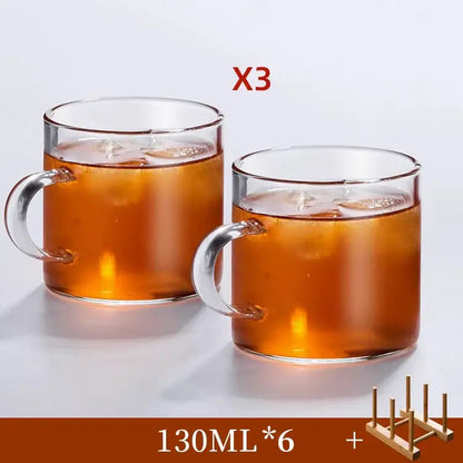 Modern heat resistant clear glass tea cup set with transparent handles filled with iced tea for dining room use