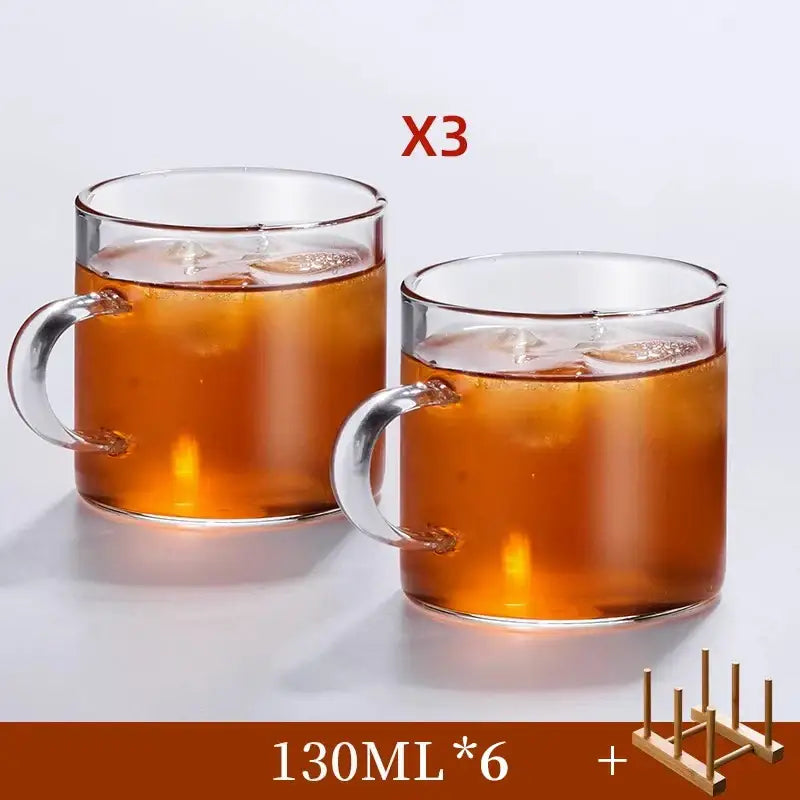 Modern heat resistant clear glass tea cup set with transparent handles filled with iced tea for dining room use