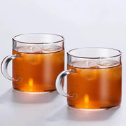 Modern heat resistant clear glass tea cup set with silver handles filled with amber iced tea for dining room use