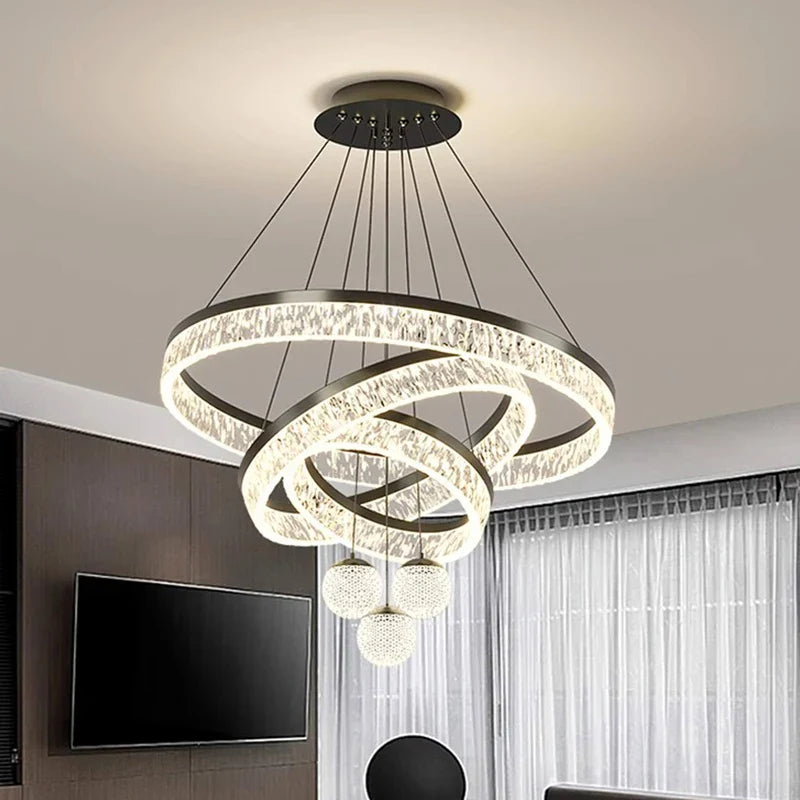 Modern black-finished metal chandelier with glowing crystal rings and three spherical LED pendant lights for indoor use