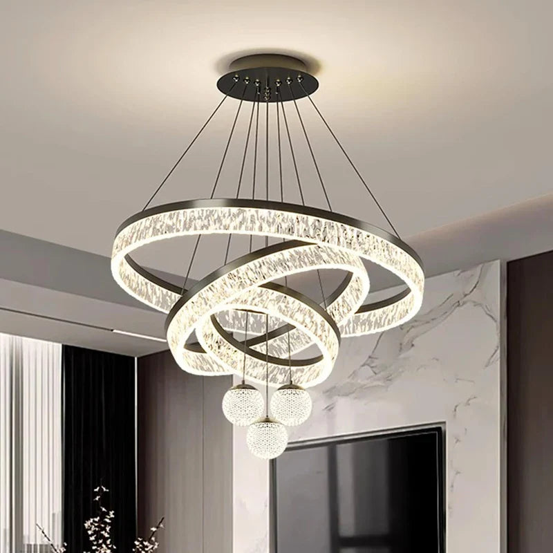Modern black metal chandelier with interlocking crystal rings and three spherical LED pendant lights for indoor living spaces