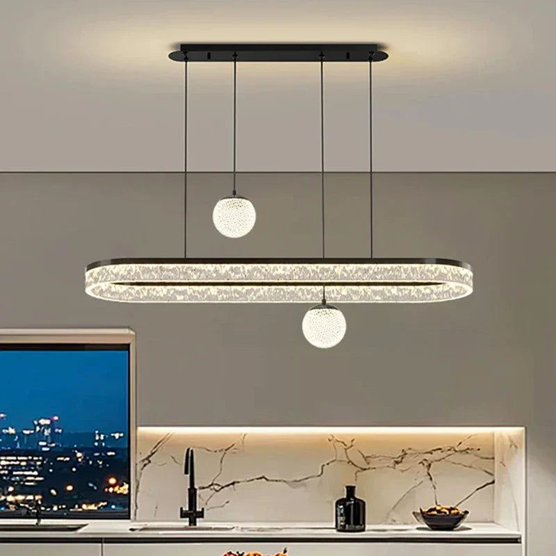 Modern black-framed oval pendant light with crystal accents and two glass globe fixtures for living and dining rooms