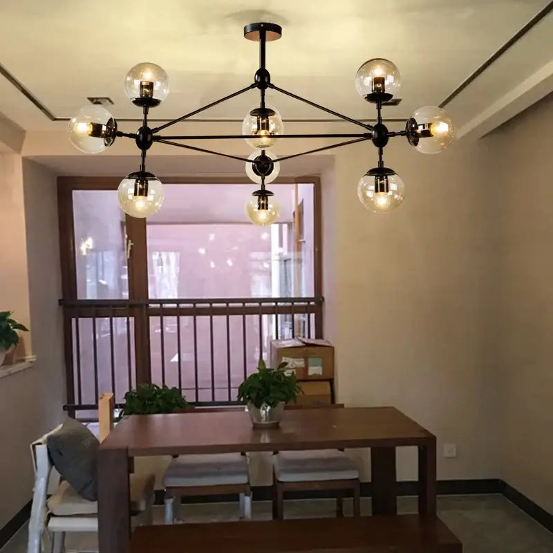 Modern industrial black metal pendant light with multiple spherical glass bean globes by decorbites for living room decor