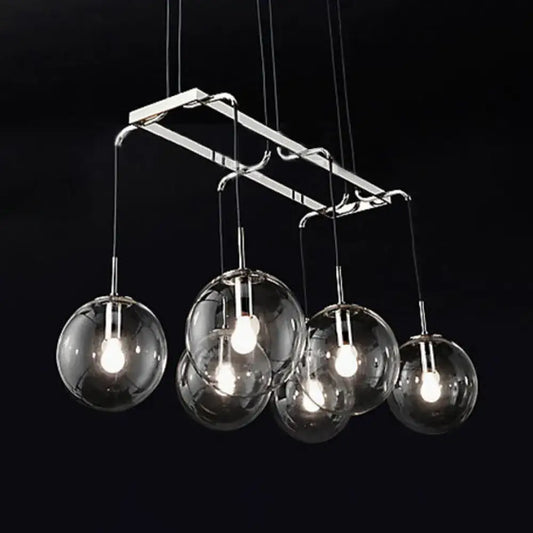 Modern chrome-finished pendant island lighting with five clear glass globe shades and smoke glass accents in nickel bronze