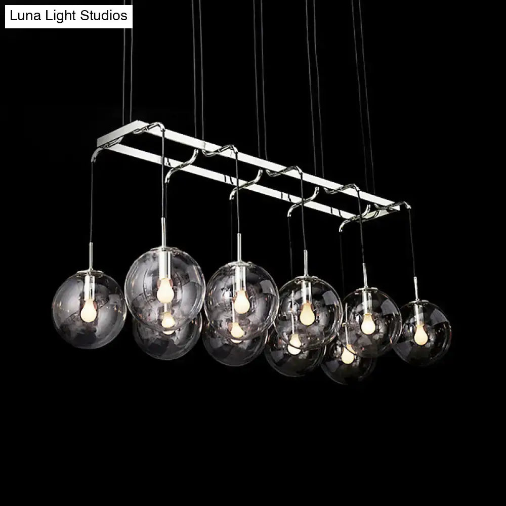 Modern chrome-finished chandelier with seven clear glass globes for stylish island lighting with smoke glass accents