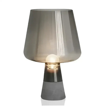 A modern industrial smoked glass and cement table lamp with a translucent gray shade and matte black base from decorbites leimu cement