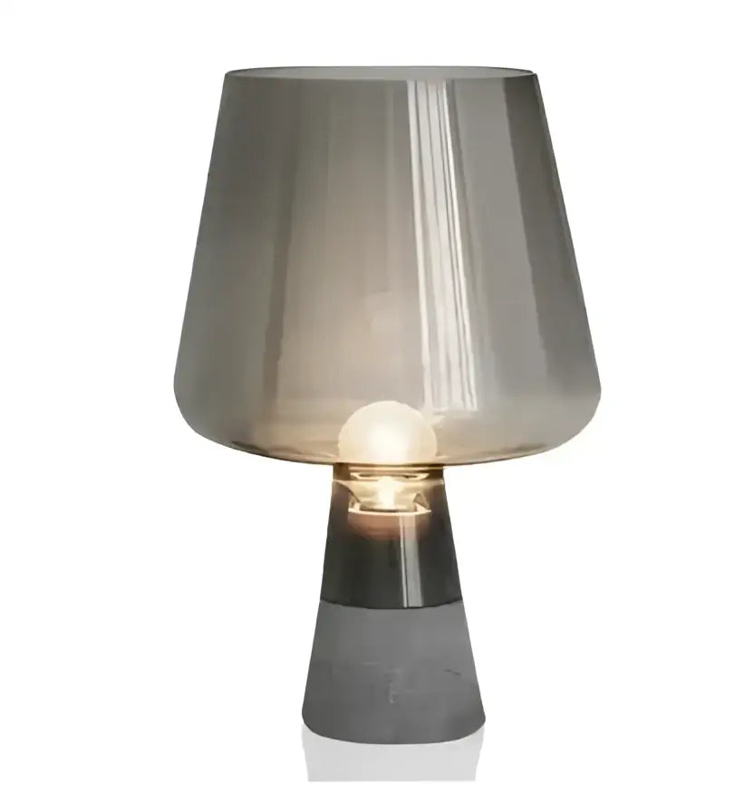 A modern industrial smoked glass and cement table lamp with a translucent gray shade and matte black base from decorbites leimu cement