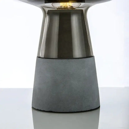 Modern industrial smoked glass and leimu cement table lamp with sleek metallic top and textured gray concrete base for bedroom decor