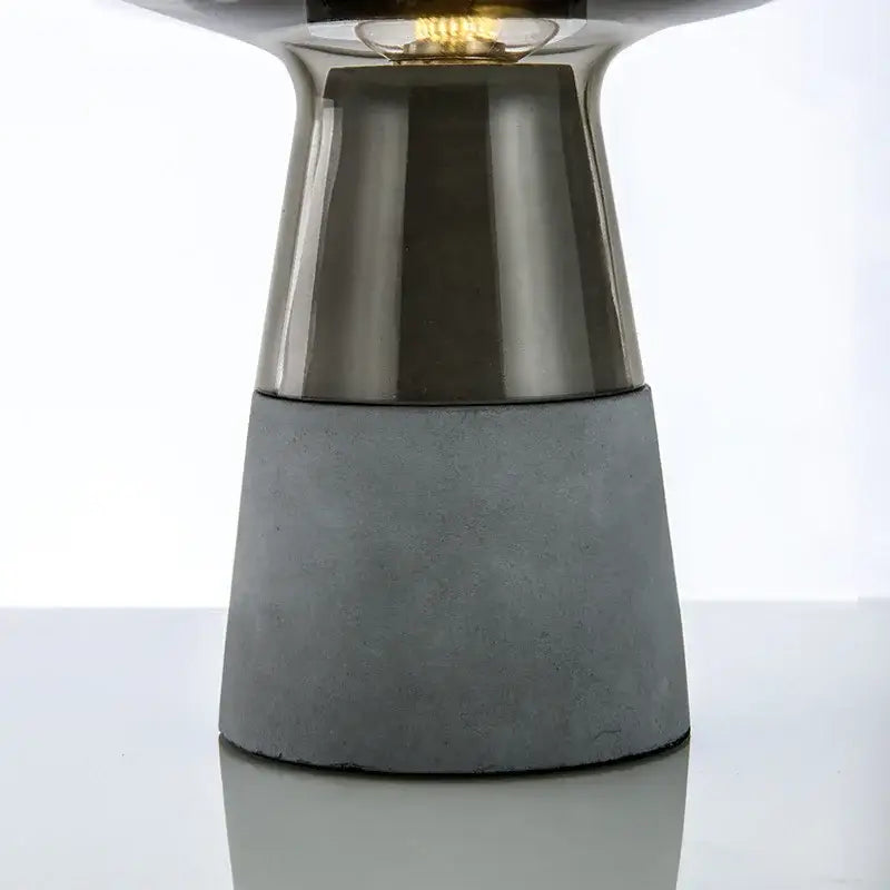 Modern industrial smoked glass and leimu cement table lamp with sleek metallic top and textured gray concrete base for bedroom decor