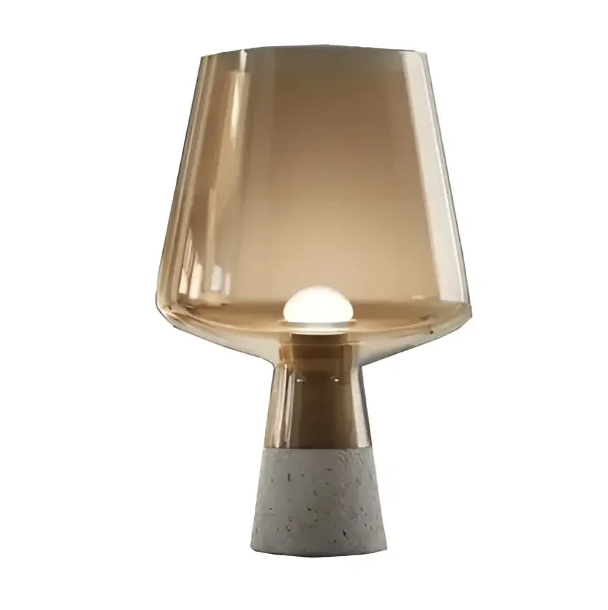 A modern industrial smoked glass and leimu cement table lamp with amber shade and polished brass collar for bedroom decor