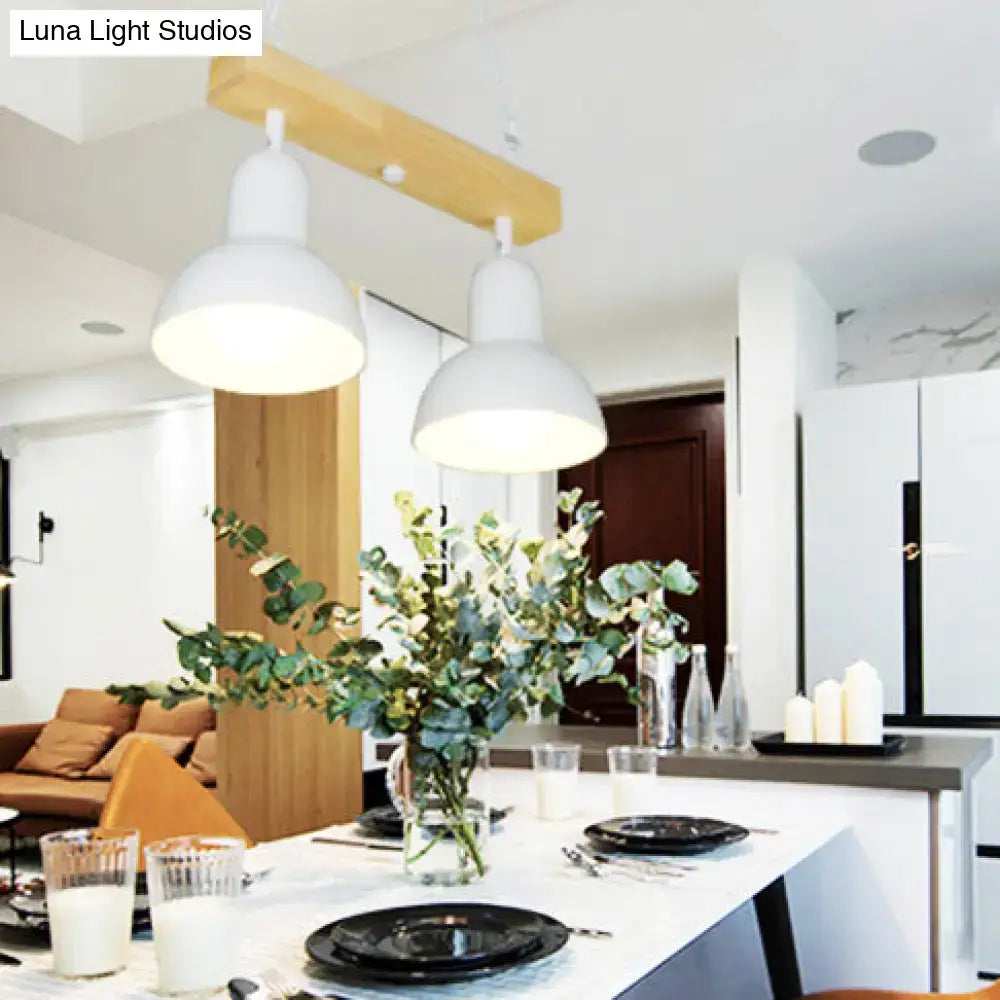 Two white island lights with wooden shades hang from a beam above a dining table in the DecorBites modern chandelier