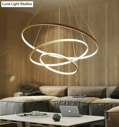 Modern pendant lights featuring three interlocking glowing rings suspended by thin cables for dining room use
