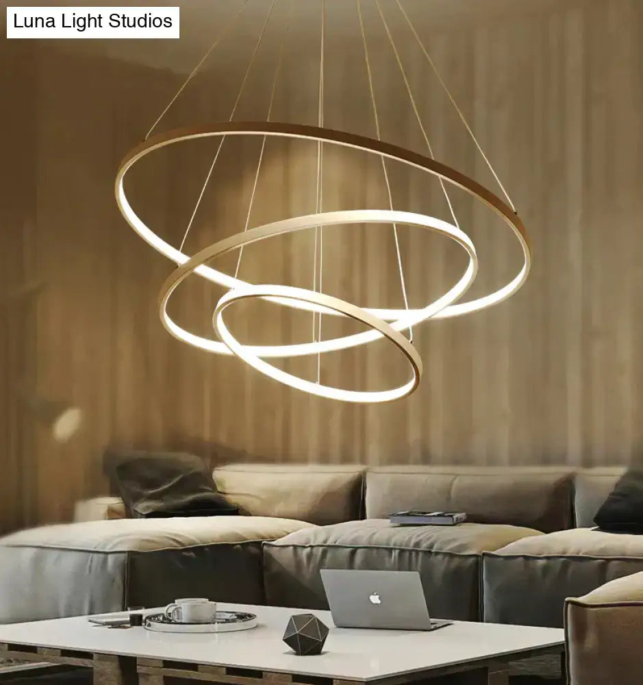 Modern pendant lights featuring three interlocking glowing rings suspended by thin cables for dining room use