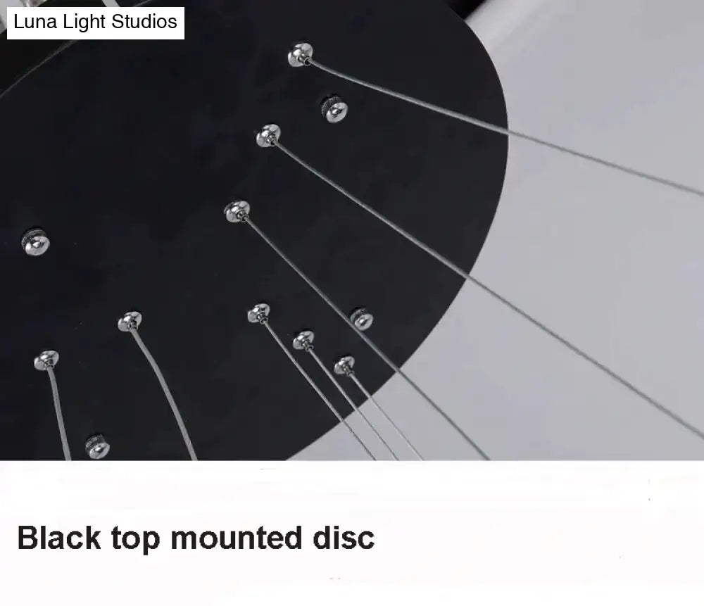 Black top-mounted disc with silver metal tuning pegs and strings featured in modern pendant lights for dining room