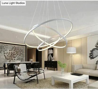 Modern white led pendant lights featuring sleek interlocking circular rings suspended by thin cables for dining rooms