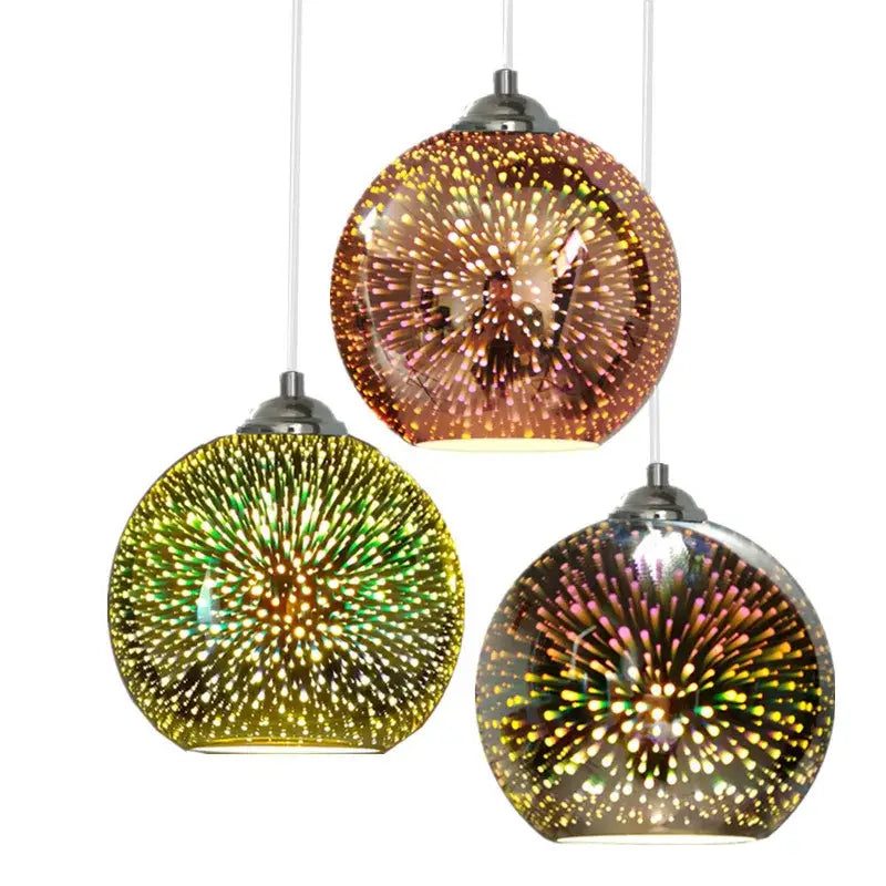 Three spherical glass pendant lights with colorful 3d glass iridescent starburst patterns in amber and green hues