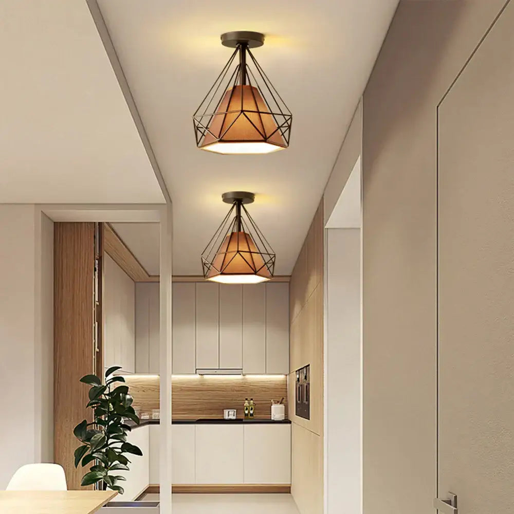 Modern iron cage ceiling lamp with warm amber glass shade and black metal frame for kitchen decorbites iron cage light