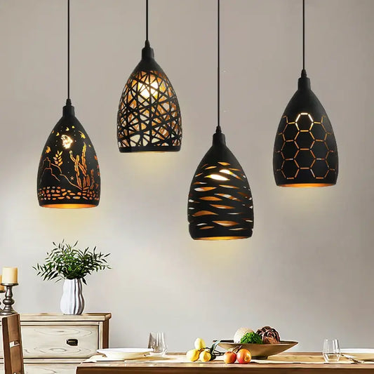 Four black iron cage pendant lights with intricate cut-out patterns and warm golden light for dining room decorbites iron cage pendant
