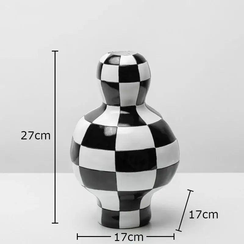 A glossy black and white checkered ceramic vase with a rounded body and narrow neck for modern room decor by decorbites black white