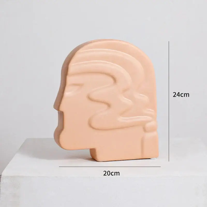 Beige ceramic sculpture of stylized human head with abstract lines for decorbites irregular ceramic vase decor
